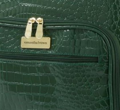 Samantha Brown croco embossed finish in green Close view of green croco embossing and the goldtone Samantha Brown plate