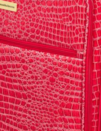 Samantha Brown croco embossed finish in red Close view of red croco embossing and a zip pocket on a Samantha Brown spinner